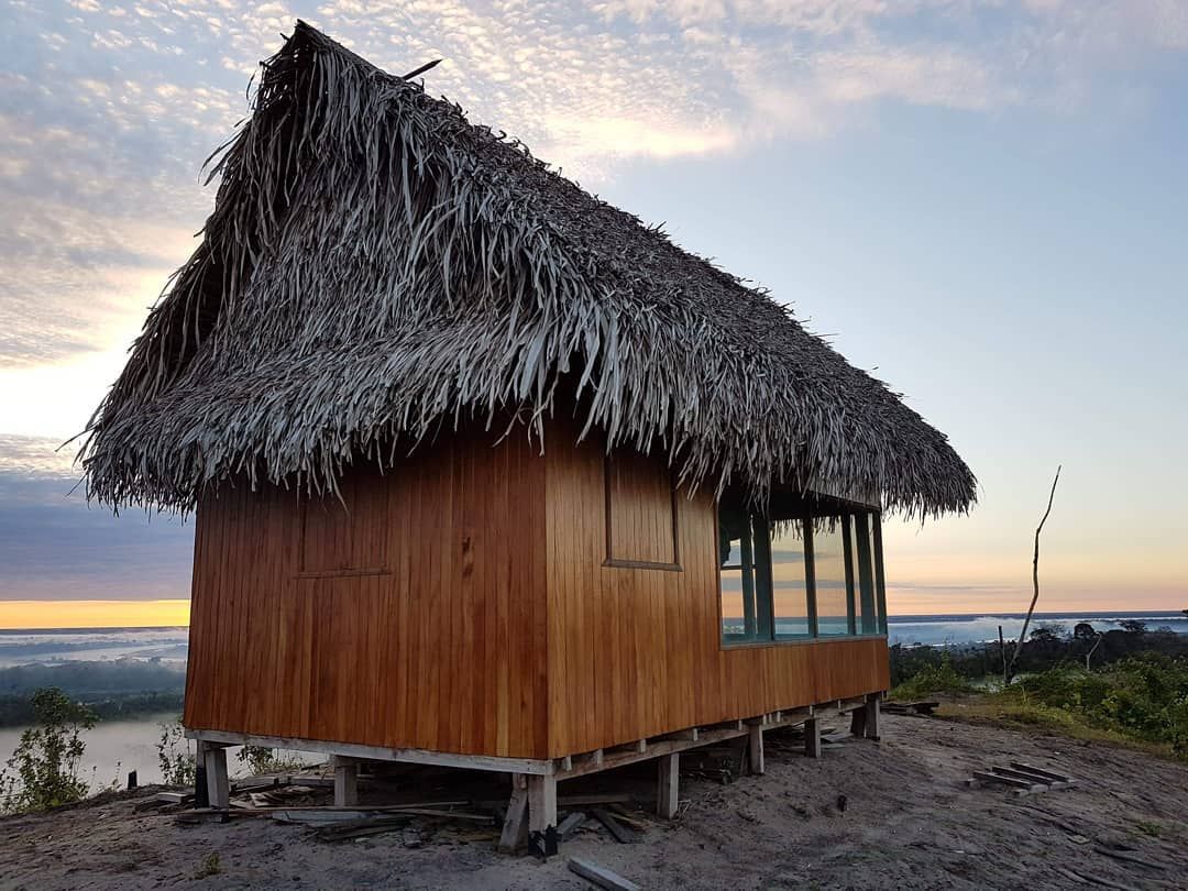Wooden hut on stilts by water, at Ampiri.