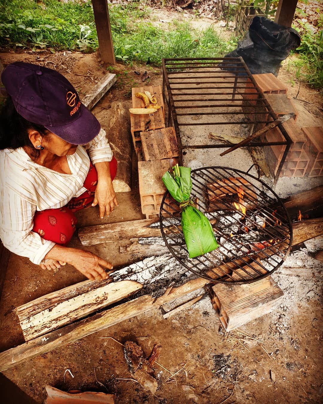 Person weaving basket, back to camera, at Ampiri.