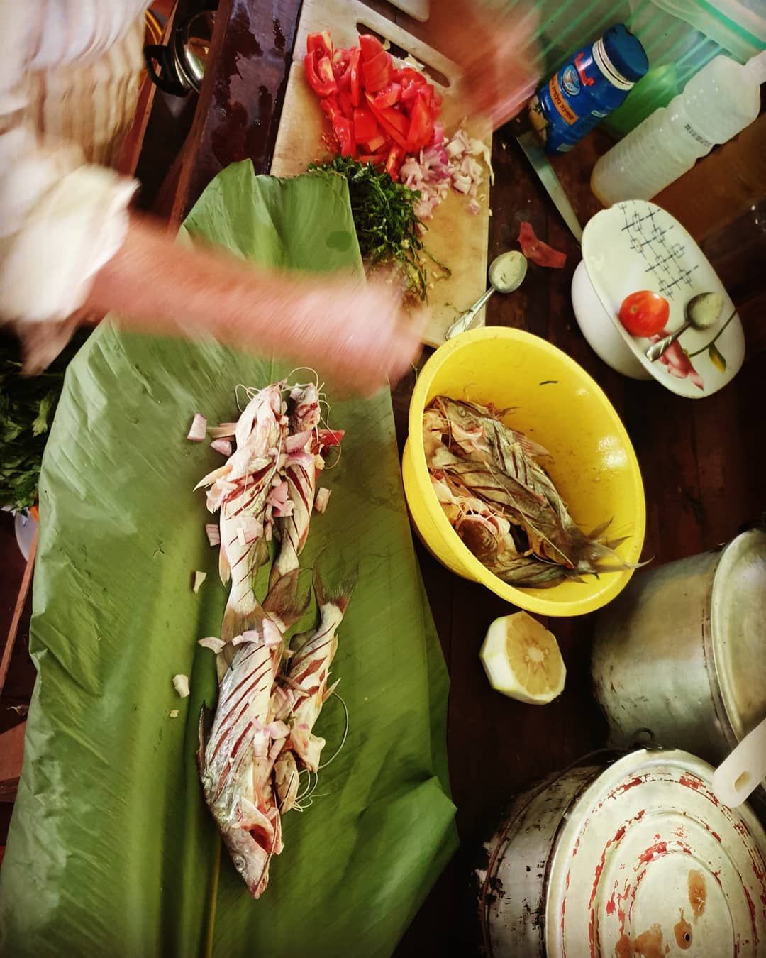 Leaf-wrapped food and hands, at Ampiri.