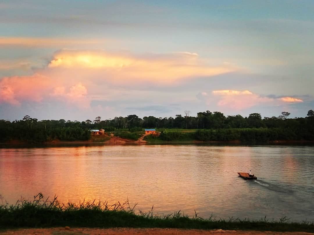 Sunset over river with boat, at Ampiri.