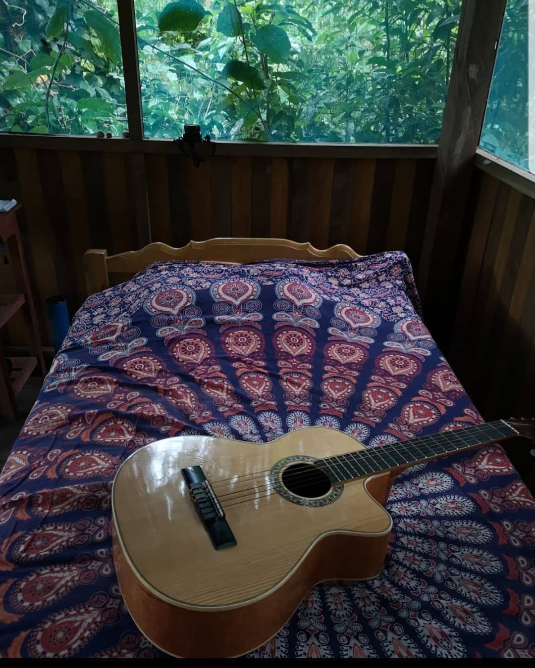 Guitar on patterned bed, at Ampiri.