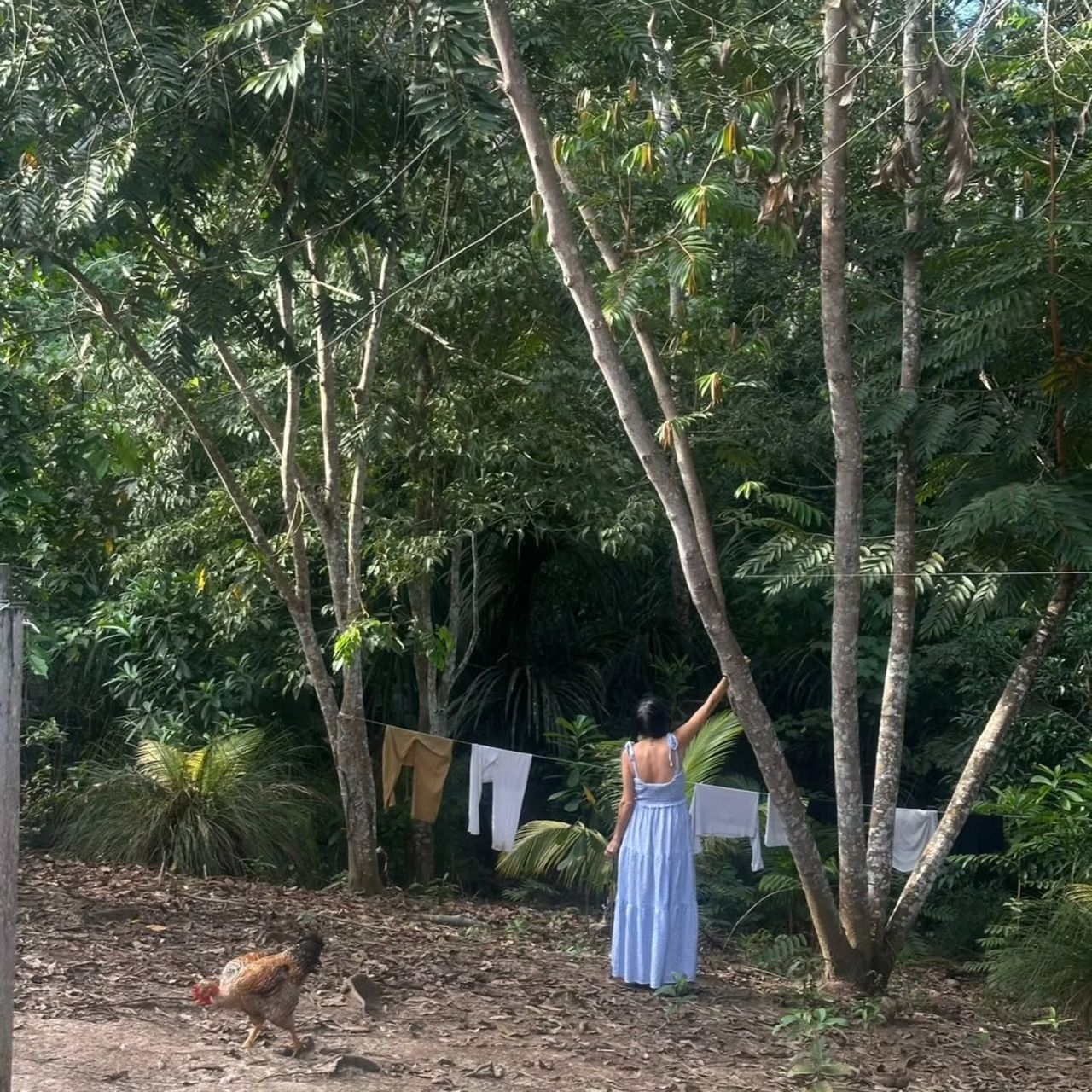 Woman hanging laundry, seen from distance, at Ampiri.